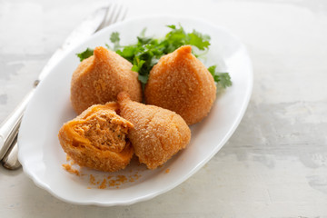 coxinha de frango, typical brazilian chicken croquette on white dish