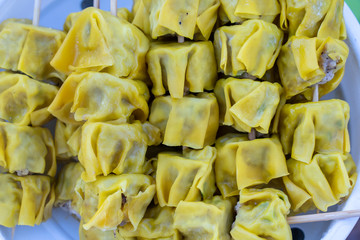 Steamed dimsum in bamboo at street food market in Thailand. Dim sum a Chinese dish of small steamed or fried savory dumplings containing various fillings, served as a snack or main course