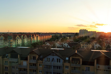 Fototapeta na wymiar Miasto, zachód słońca nad dachami osiedla mieszkaniowego.
