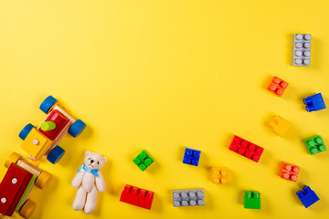 Various children's toys on yellow background. Space for text in the center of the image.