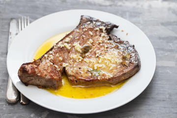 fried tuna with garlic, bay leaf and olive oil on white plate