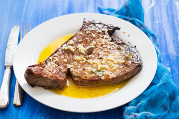 fried tuna with garlic, bay leaf and olive oil on white plate