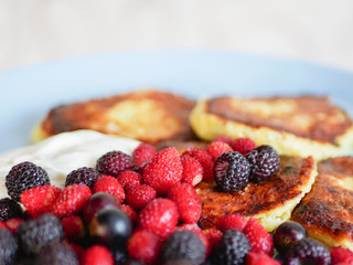 pancakes with berries. and sour cream. Cheesecakes served with lots of fresh berries. Gourmet breakfast - curd cheesecakes, curd pancakes with raspberries, strawberries, blueberries. Close. healthy fo