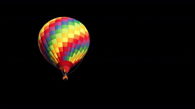 A colorful hot air balloon coming closer against a black background.