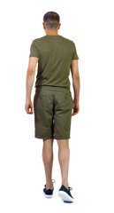 Fototapeta premium Back view of going handsome man in shorts.