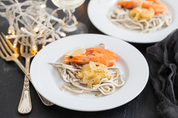 Traditional Spanish food. Gulas with oil and shrimp on white plate.