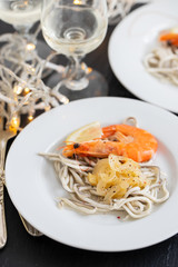 Traditional Spanish food. Gulas with oil and shrimp on white plate.