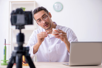 Young male doctor dentist recording video for his blog