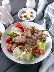 Grilled meat and salad with vegetables, mozzarella and herbs. Traditional Mediterranean Cuisine