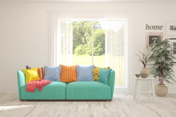 Naklejka premium Stylish room in white color with sofa and summer landscape in window. Scandinavian interior design. 3D illustration
