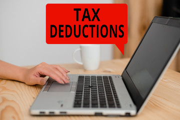 Text sign showing Tax Deductions. Business photo showcasing an amount or cost that subtracted from someone s is income woman laptop computer smartphone mug office supplies technological devices