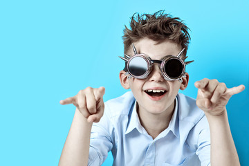 rocker boy in blue shirt and biker glasses on a light blue background