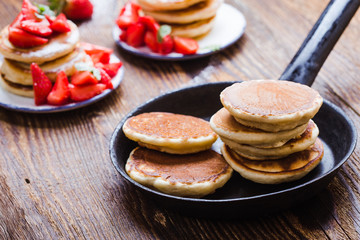 Cooking pancakes with fresh summer strawberries
