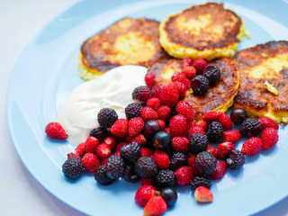 pancakes with berries. and sour cream. Cheesecakes served with lots of fresh berries. Gourmet breakfast - curd cheesecakes, curd pancakes with raspberries, strawberries, blueberries. Close. healthy fo