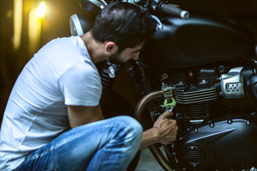  man repairing his motorcycle in the garage.