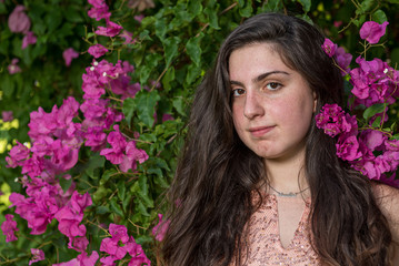 Naklejka premium Attractive young beautiful lady, enjoying the pink blooming flowers. Concept of welcoming Spring