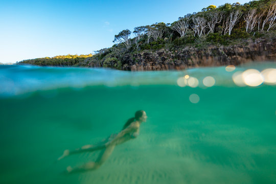 A woman is swimming underwater by Noosa National Park, Noosa Heads, Queensland, Australia