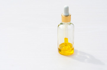 yellow natural cosmetic product in a glass bottle with a pipette, dropper on a white background, isolated. Serum skin care. copy space, mock up.