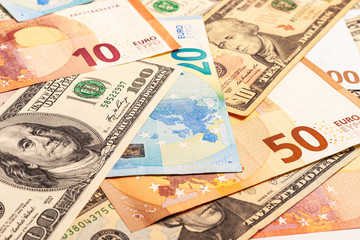 Fototapeta na wymiar Euro and dollars paper money in cash. The two leading currencies of the world are US dollars and euros. Texture of multiple US dollars and euros banknotes. Background from paper money.