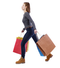 side view of a woman jumping with shopping bags.