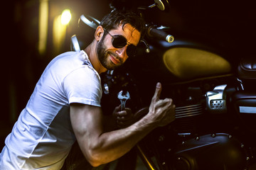  man repairing his motorcycle in the garage.