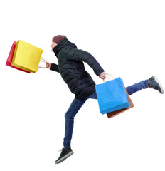 Side view of a man in winter jacket with shopping bags that runs.