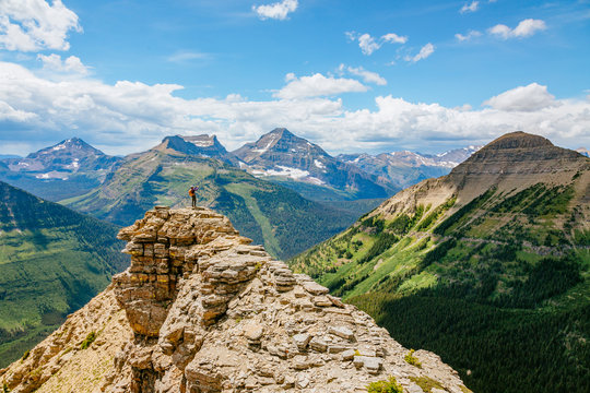 A woman photographs the view on the loop trail from Two Medicine over Dawson Pass, Glacier National Park, Montana, USA.