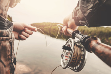 Fisherman using rod fly fishing in river