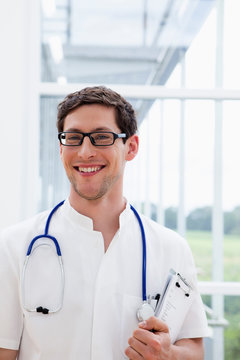 Germany, Bavaria, Diessen am Ammersee, Close up of young doctor with stethoscope, smiling, portrait