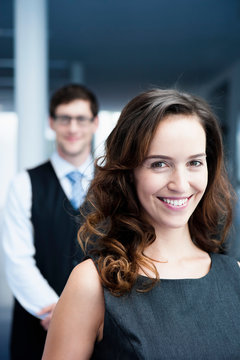 Germany, Bavaria, Diessen am Ammersee, Businesswoman standing in front of businessman, smiling