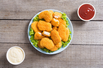 Chicken nuggets in plate on rustic background