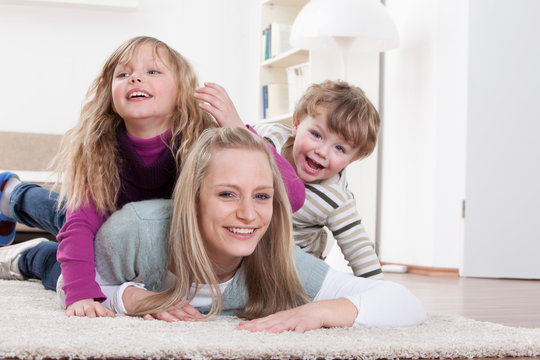 Germany, Bavaria, Munich, Mother, daughter and son lying on floor at home
