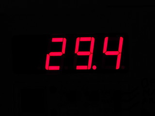 Digital LCD display of thermometer showing hot temperature in Ce