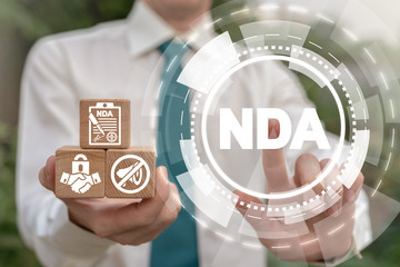 NDA Non-Disclosure Agreement Business concept. Man holding wooden cubes with confidentiality icons...