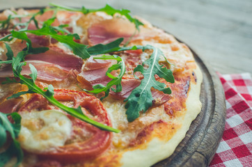 Italian pizza with prosciutto and arugula
