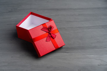 Open Red square holiday gift box against a dark background