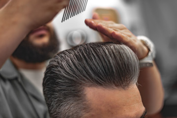 Men's beauty salon. The man makes a haircut.