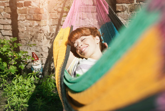 Germany, Berlin, Young woman in hammock, smiling