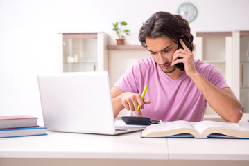 Young male student preparing for exams at home