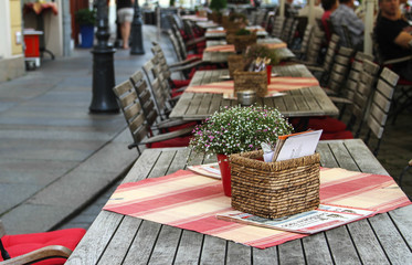 Summer European cafe with flowers on the tables on the city street
