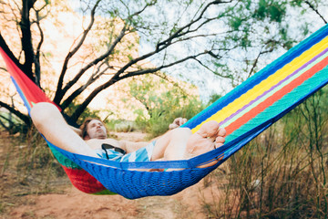 A man relaxes in a hammock on a Colorado River trip, Grand Canyon National Park, Arizona, USA