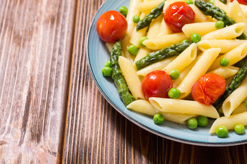 Penne pasta salad with asparagus , tomatoes and peas