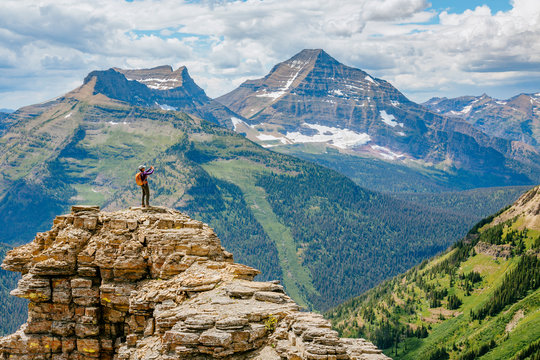 A woman photographs the view on the loop trail from Two Medicine over Dawson Pass, Glacier National Park, Montana, USA.