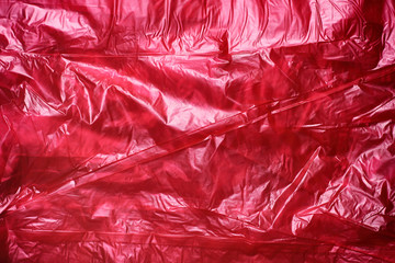 Obraz premium Red crumpled plastic garbage bag texture background. Waste recycle concept. Pattern of materials. 