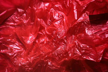 Red crumpled plastic garbage bag texture background. Waste recycle concept. Pattern of materials. 