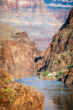 A woman stands above the Colorado River at Mile 136 of a rafting trip, Grand Canyon National Park, Arizona, USA