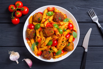 Italian penne pasta with meatballs and tomatoes