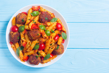 Italian penne pasta with meatballs and tomatoes