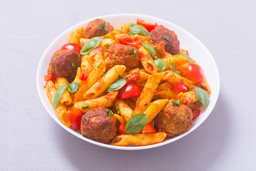 Italian penne pasta with meatballs and tomatoes