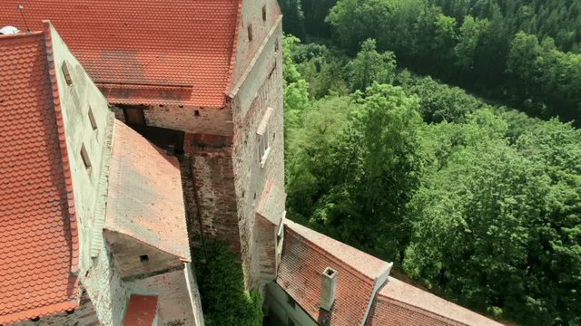 Aerial Close Up Stone Wall and Roof of Fairytale Medieval Pernstejn Castle (hrad Pernstejn) in Moravia, Czech Republic, Europe on Sunny Summer Day. 4K Drone Tilt Shot